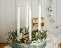 Adventskranz in einer hellen Schale mit weißen Spiralkerzen