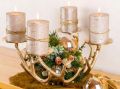 Moderner Adventskranz: vier Kerzen auf goldenem Geweih-Kerzenständer